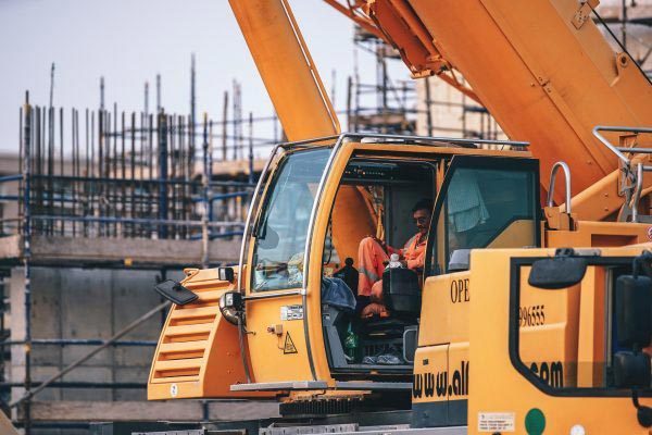 Crane operator in orange crane on building site